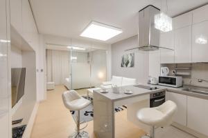 a kitchen with a counter and two stools in it at Elite Apart-Hotel in Astana