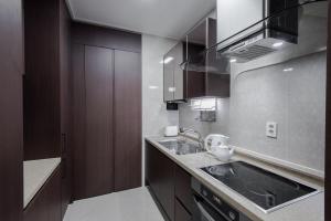 a kitchen with wooden cabinets and a sink at Elite Apart-Hotel in Astana