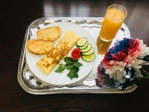 a plate of food on a table with a glass of orange juice at Sultan Beibarys in Astana