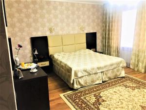 a bedroom with a bed and a table and a rug at Sultan Beibarys in Astana