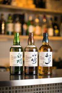 drie flessen whisky op een plank bij Imu Hotel Kyoto in Kyoto