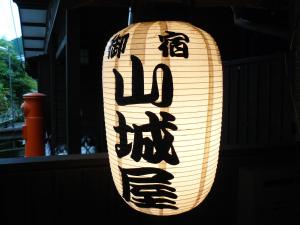 a lit up lantern with writing on it at Ryokan Yamashiroya in Yufuin