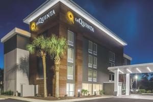 ein Gebäude mit Palmen davor in der Unterkunft La Quinta by Wyndham Myrtle Beach - N. Kings Hwy in Myrtle Beach