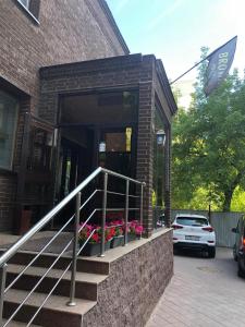 a brick building with stairs and flowers in front of it at Brown Hotel in Astana