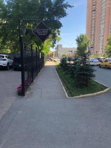 a black gate with a sign on it next to a street at Brown Hotel in Astana