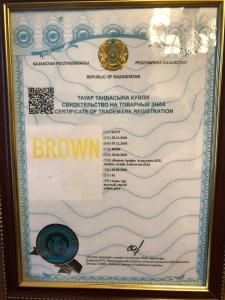 a framed picture of a brown document in a gold frame at Brown Hotel in Astana