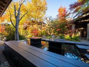 einen Garten mit einer Bank und einem Teich in der Unterkunft Yufuin Bettei Itsuki in Yufu