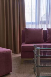 a living room with a purple couch and a table at Altyn Eco Park in Astana