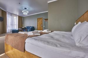 a large bed in a hotel room with towels on it at Altyn Eco Park in Astana