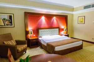 a hotel room with a bed and a chair at Diplomat Hotel by AG Hotels Group in Astana