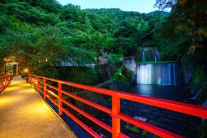 Beppu Showaen في بيبو: جسر احمر مع شلال وسياج احمر