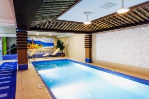 a swimming pool in a building with a large window at Diplomat Hotel by AG Hotels Group in Astana