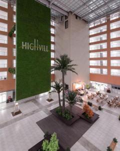 a large lobby with palm trees in a building at Elite Apart-Hotel in Astana