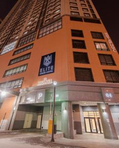 a tall orange building with a sign on it at Elite Apart-Hotel in Astana