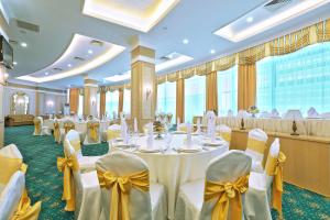 a banquet hall with white tables and yellow bows at Diplomat Hotel by AG Hotels Group in Astana