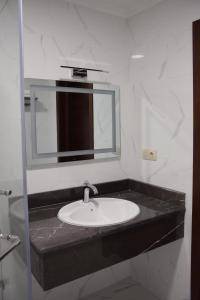 a bathroom with a sink and a mirror at MirOtel Hotel in Astana