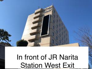 un edificio con le parole davanti all'uscita ovest della stazione di urnia di Narita U-City Hotel a Narita