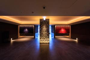 eine Lobby mit einer Steinsäule in der Mitte eines Raumes in der Unterkunft Beppu SUGINOI HOTEL in Beppu