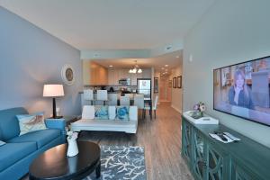 ein Wohnzimmer mit einem blauen Sofa und einem TV in der Unterkunft Huge Ocean Front Condo, Amazing Views in Myrtle Beach