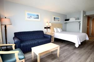 ein Hotelzimmer mit einem Bett und einem blauen Sofa in der Unterkunft Holiday Sands North "On the Boardwalk" in Myrtle Beach