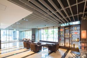 eine Lobby mit einem Sofa, Stühlen und Fenstern in der Unterkunft Hotel Forza Oita in Ōita