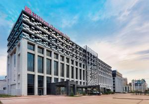 a large white building with a red sign on it at Hilton Garden Inn Astana in Astana