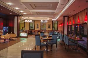 a dining room with tables and chairs in a restaurant at Hilton Garden Inn Astana in Astana