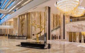 a lobby with a chandelier and a sculpture in the middle at Hilton Astana in Astana