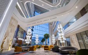 a lobby with chairs and tables in a building at Hilton Astana in Astana