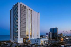 Ein hohes weißes Gebäude in der Nacht in der Unterkunft Hilton Grand Vacations Club Ocean Enclave Myrtle Beach in Myrtle Beach