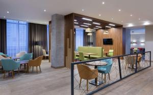 a restaurant with tables and chairs in a lobby at Hampton By Hilton Astana Triumphal Arch in Astana