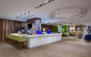 two people standing at a counter in a lobby at Hampton By Hilton Astana Triumphal Arch in Astana