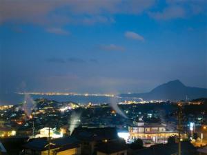 Blick auf die Stadt in der Nacht mit Lichtern in der Unterkunft 〜Ｇｒａｎｄｐｉａ Ｒｅｓｏｒｔ ＯＵＧＩＹＡＭＡ〜 - Vacation STAY 51002v in Beppu