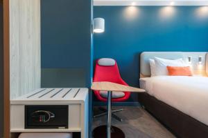 a room with a bed and a red chair at Holiday Inn Express - Astana - Turan by IHG in Astana