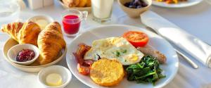 a white plate of breakfast food on a table at Five Hotel in Astana