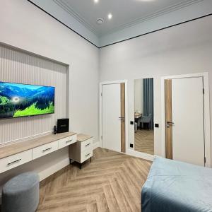 a bedroom with a bed and a tv on a wall at Five Hotel in Astana