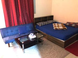 a room with a bed and a couch and a table at Premium Furnished studio in Sharjah