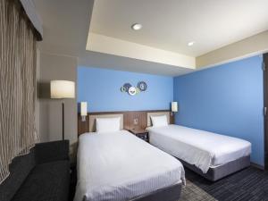 ein Hotelzimmer mit 2 Betten und einer blauen Wand in der Unterkunft ibis Styles Kyoto Shijo in Kyoto