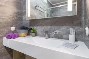 a bathroom with a white sink and a mirror at Отель у Ботанического Сада, в самом центре in Astana