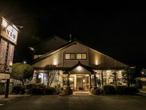 a building with a sign in front of it at night at Asobe in Aso