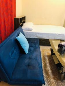 a blue couch in a room with a bed at Premium Furnished studio in Sharjah