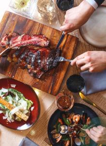 a table with plates of food on a wooden cutting board at The Ritz-Carlton, Astana in Astana