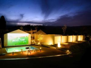 een groot gebouw met een zwembad in de nacht bij Kosugi Resort in Aso