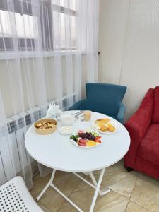 a white table with plates of food on it at Baiterek Premium in Astana