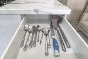 a drawer with silver utensils on a table at Expo Inn апартаменты напротив Ботанического сада in Astana