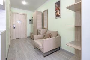 a living room with a chair and a door at Expo Inn апартаменты напротив Ботанического сада in Astana