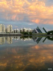 a city skyline with buildings and a body of water at Expo Inn апартаменты напротив Ботанического сада in Astana