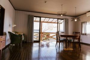 a dining room with a table and chairs and a balcony at Hakusyu - Vacation STAY 11460v in Aso