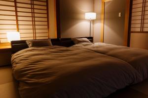 a large bed in a room with two lamps at Hakusyu - Vacation STAY 11460v in Aso