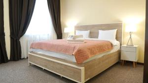 a bedroom with a large bed with a orange blanket at ASYR Hotel in Astana